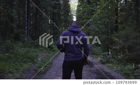 Young man wearing a hat in the woods. Athlete came into the forest to do sports 109793699