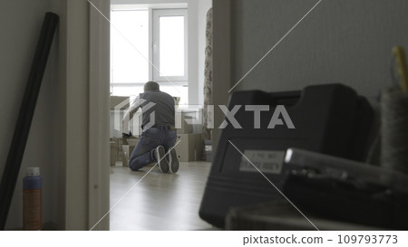Man is looking for something in a box, general view Man is looking for something in a box, general view 109793773