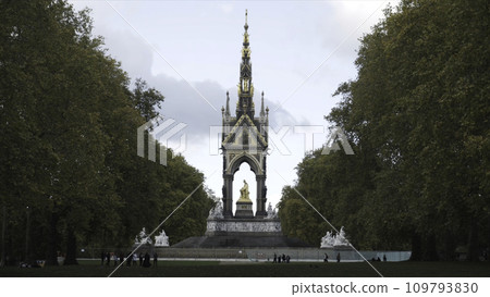 Beautiful view of the golden Albert Memorial surrounded by large green trees in Kensington gardens, London, UK. Action. England landmarks Beautiful view of the golden Albert Memorial surrounded by large green trees in Kensington gardens, London, UK. Action. England landmarks 109793830