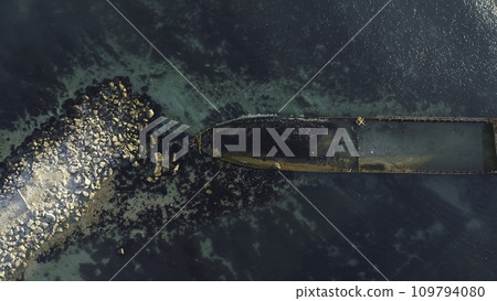 Aerial view of the rusty sunken ship stuck on a rocky shoal. Shot. Old seagoing vessel Aerial view of the rusty sunken ship stuck on a rocky shoal. Shot. Old seagoing vessel 109794080