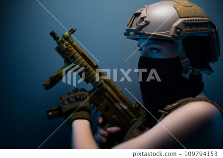sexy girl soldier in a helmet, armed with an automatic rifle, in military clothes on a blue background sexy girl soldier in a helmet, armed with an automatic rifle, in military clothes on a blue background 109794153