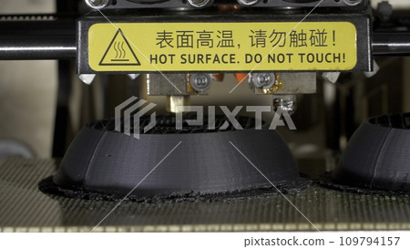Close up of a modern 3D printer. Head of 3d printer in action. Close Up Of 3D Printer Operating In Design Studio 109794157