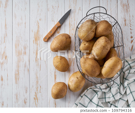 fresh organic potato on a white wooden table, top view 109794316