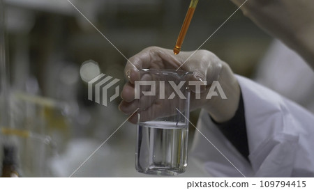 Chemist hands mixed substance of red color in test tubes. Doctor Pours red Chemicals Into In Flask. Close Up 109794415
