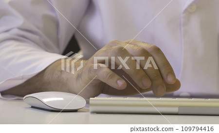 Hands typing on the keyboard. Male hands or man office worker typing on the keyboard 109794416