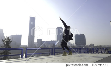 Young woman dancing on city background. Street dancer girl on an city background. Dancing hipster girl in the street 109794462