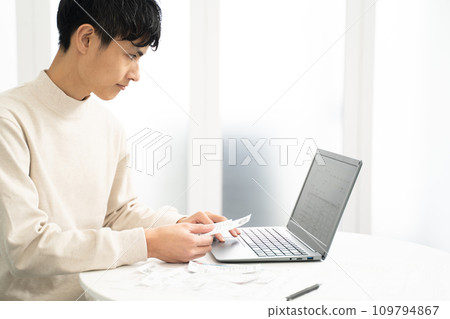 一名男子正在整理收據,準備最終報稅表 一名男子正在整理收據,準備最終報稅表 109794867