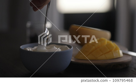 man swirl white yogurt in bowl 109795468