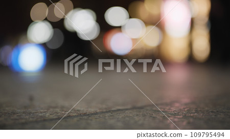 Low angle bokeh background of night city with car light passing by Low angle bokeh background of night city with car light passing by 109795494