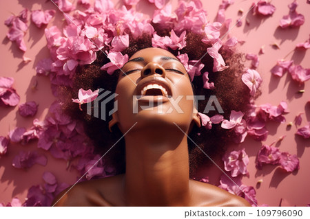 Young African American woman having orgasm. Beautiful woman with open mouth and closed eyes enjoying sex lying among rose petals. Sexual experience, getting sexual pleasure, masturbation, cunnilingus. 109796090