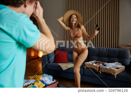 Happy young man and woman packing bags for vacation trip 109796126