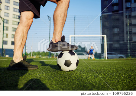Family playing football on field, focus on father foot on ball 109796226