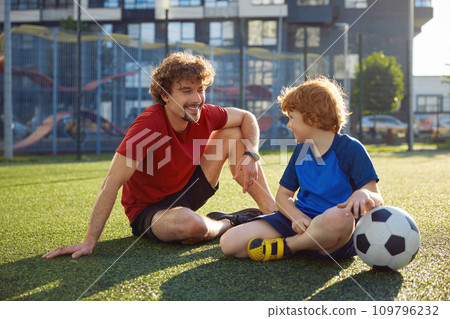 Young father teaching little son playing football 109796232