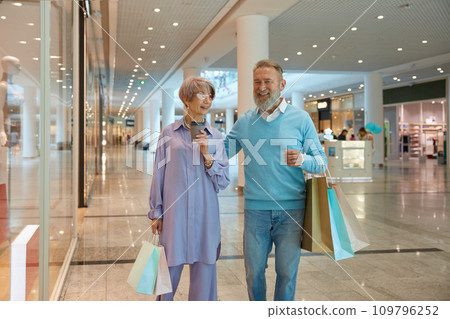 Overjoyed senior couple with shopping bags rejoicing successful purchases Overjoyed senior couple with shopping bags rejoicing successful purchases 109796252