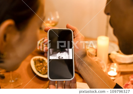 一對夫婦在智慧型手機上查看寶寶的外表 109796327