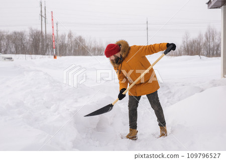 Man removing snow and ice from the sidewalk in front of house. Winter season Man removing snow and ice from the sidewalk in front of house. Winter season 109796527