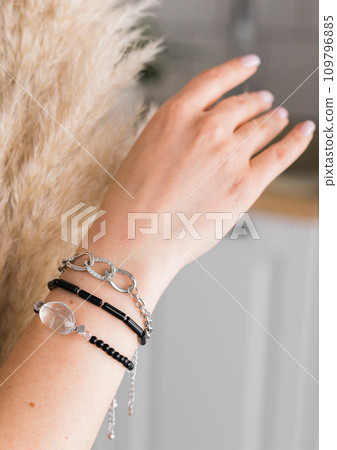 Close-up woman wearing beautiful luxury bracelets. Handmade jewellery and accessories Close-up woman wearing beautiful luxury bracelets. Handmade jewellery and accessories 109796885