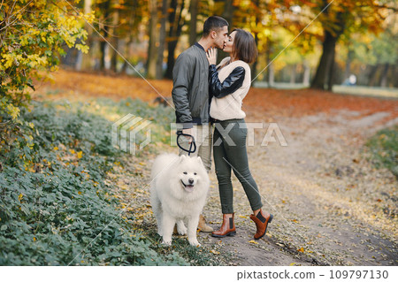 lovely couple walking around the park with dog during autumn lovely couple walking around the park with dog during autumn 109797130