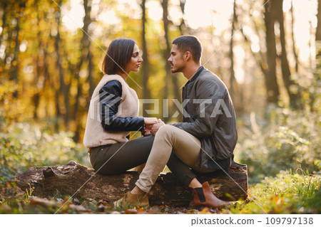 lovely couple sitting in the park during autumn 109797138