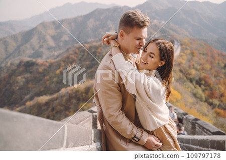 beautiful young couple showing affection on the Great Wall of China. Newly married couple on their honemoon to Great Wall near Beijing China. Stylish couple exploring one of the wonders of the world beautiful young couple showing affection on the Great Wall of China. Newly married couple on their honemoon to Great Wall near Beijing China. Stylish couple exploring one of the wonders of the world 109797178
