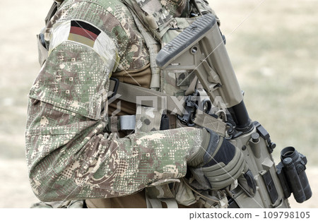 Soldier with assault rifle and flag of Germany on military uniform. Collage. Soldier with assault rifle and flag of Germany on military uniform. Collage. 109798105
