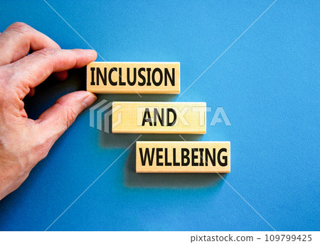 Inclusion and wellbeing symbol. Concept words Inclusion and wellbeing on wooden block. Beautiful blue table blue background. Doctor hand. Motivational inclusion and wellbeing concept. Copy space. 109799425