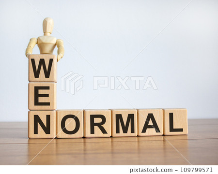 Concept words 'new normal' on cubes on a beautiful wooden table. Wooden model of human. Beautiful white background. Concept words 'new normal' on cubes on a beautiful wooden table. Wooden model of human. Beautiful white background. 109799571
