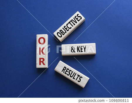 OKR objectives and key results symbol. Wooden blocks with words OKR objectives and key results. Beautiful deep blue background. Business and OKR concept. Copy space. 109800811