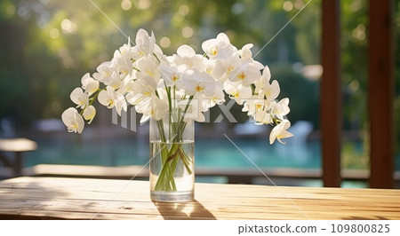 clear clear vase filled with white orchids and water on wooden table 109800825