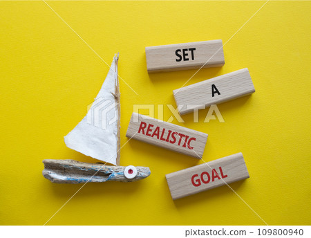 Set a realistic goal symbol. Concept words Set a realistic goal on wooden blocks. Beautiful yellow background with boat. Business and Set a realistic goal concept. Copy space. Set a realistic goal symbol. Concept words Set a realistic goal on wooden blocks. Beautiful yellow background with boat. Business and Set a realistic goal concept. Copy space. 109800940