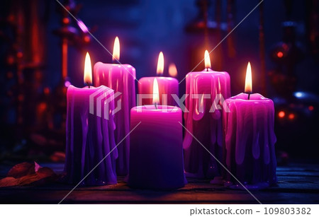 several purple candles lit on the dark background 109803382