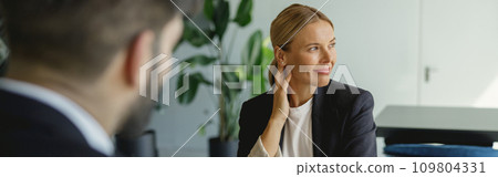 Two business colleagues working on project while sitting in office meeting room Two business colleagues working on project while sitting in office meeting room 109804331