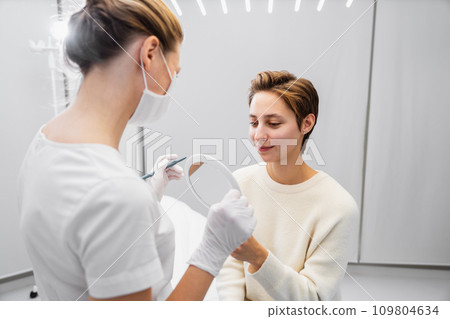 A young woman consults a beautician about her face. A young woman consults a beautician about her face. 109804634