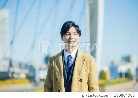 A young man in a suit walking in the winter city 109804765