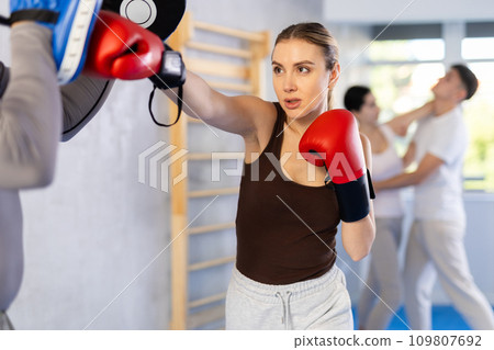 Young woman training in boxing fight in studio Young woman training in boxing fight in studio 109807692