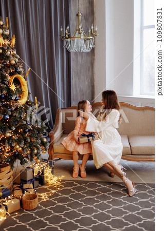Mother giving Christmas gift to daughter. Mother giving Christmas gift to daughter. 109807831