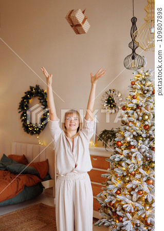 A woman throws a rad in the Christmas living room A woman throws a rad in the Christmas living room 109807898