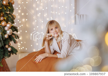Woman with gift on bed at Christmas Woman with gift on bed at Christmas 109807937