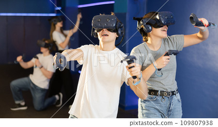 Portrait of young woman with virtual reality glasses standing in room 109807938