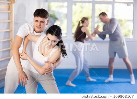 Young girl practicing self-defense techniques in pairs with guy 109808167