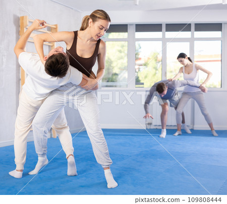 Young girl applying throwing technique on her opponent in sports hall 109808444