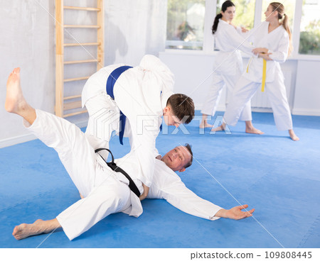 Adult man and young guy training judo techniques Adult man and young guy training judo techniques 109808445