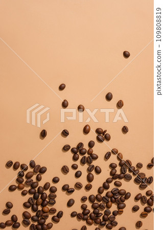 Coffee beans scattered on a pink background. Ideal space for displaying products containing coffee extract. Get creative with coffee beans for advertising. Coffee beans scattered on a pink background. Ideal space for displaying products containing coffee extract. Get creative with coffee beans for advertising. 109808819