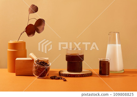 A cup of black coffee is displayed on a log, autumn leaves are placed in a ceramic vase. Coffee display space for advertising. Coffee contains many antioxidants that are beneficial for the skin. 109808825