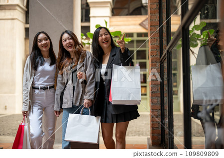 Group of fun attractive young Asian girls are enjoying shopping in the city together on the weekend. 109809809