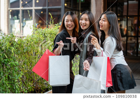 Young happy and attractive three Asian girls are enjoying shopping on the weekend together. 109810038