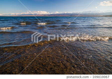 Ultra-wide angle view of small waves on mountain lake at sunny day. Low angle view. 109810067