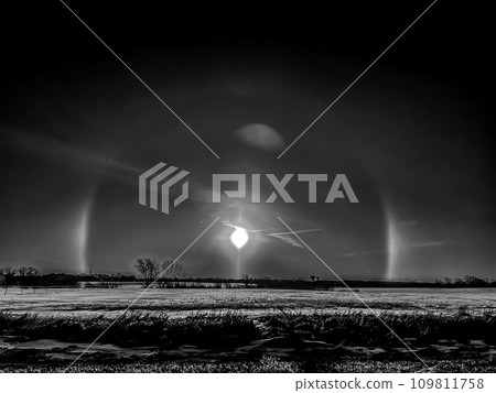 Atmospheric optical phenomenon sun dogs in the morning across a snow field. Atmospheric optical phenomenon sun dogs in the morning across a snow field. 109811758