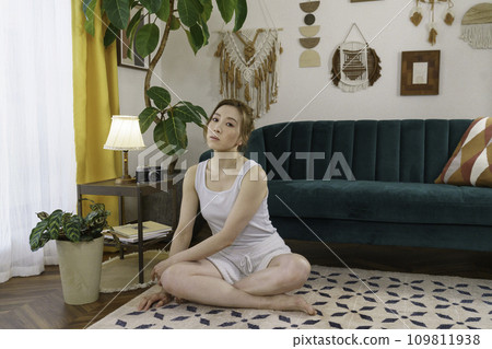 一位年輕女子坐在客廳地板上的肖像 一位年輕女子坐在客廳地板上的肖像 109811938
