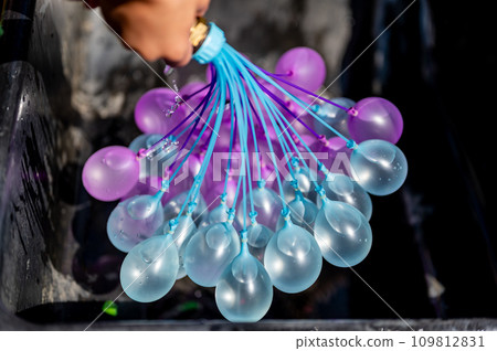 Rapid filling self sealing water balloons being inflated with a hose. Rapid filling self sealing water balloons being inflated with a hose. 109812831